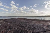 an out standing on the rock that surrounds the water from the rocky beach in the area