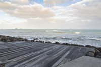 the boardwalk has a very nice looking surface near the ocean for the view, a lot of rocks in the water