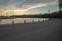 a person on a bench at a marina near the water and a row of boats