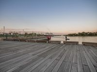 a picture of a wooden deck that has bench seating near it and the water in the background