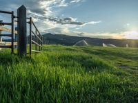 a lone country road is in the countryside area with mountains on both sides and barbed fence between the two sides