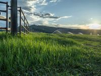 a lone country road is in the countryside area with mountains on both sides and barbed fence between the two sides