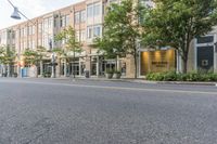 an empty street in front of a large building with windows on each side of the street