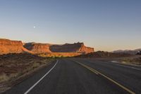 Dawn in the Desert: Highway Through the Mountains and Clear Sky