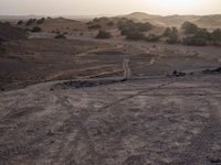 a truck on a dirt road in the desert with rocks and stones on the ground