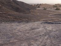 a truck on a dirt road in the desert with rocks and stones on the ground