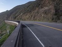 motorcycle parked on a hill above the sea shore as seen from a car window in a photo