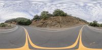 three straight lanes with an orange stripe on the side of a mountain road, in this 360 - pano view