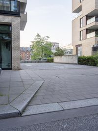 a parking lot with steps leading to a building and some bushes in it with an empty patio behind it