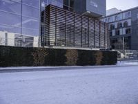 a sidewalk in front of a very big building in the snow on a cold winter day