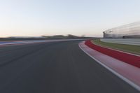 Dawn on the Highway: Racing Red Automobiles on a Race Track