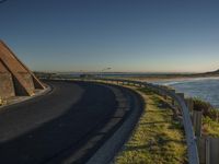 a lone road winds through the ocean beside a beach side area on the shoreline road