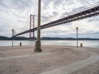 the bridge crosses the water on a clear day with no clouds on it and people sitting around