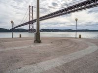 the bridge crosses the water on a clear day with no clouds on it and people sitting around