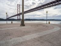 the bridge crosses the water on a clear day with no clouds on it and people sitting around