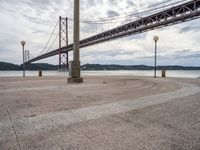 the bridge crosses the water on a clear day with no clouds on it and people sitting around