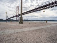 the bridge crosses the water on a clear day with no clouds on it and people sitting around