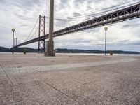 the bridge crosses the water on a clear day with no clouds on it and people sitting around