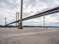 the bridge crosses the water on a clear day with no clouds on it and people sitting around