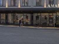 a person is outside the amano grand - center hotel entrance at night with no lights