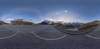 there is a circular lens effect on this street view of a mountain and sky behind