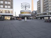 a square that has bicycles parked in the middle of it and a building in the background