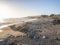 a grassy field by the shore and a cliff with rocks in the ocean in the background