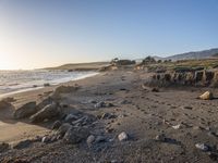 a grassy field by the shore and a cliff with rocks in the ocean in the background