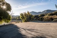 empty empty parking lot with mountains and trees in the background on a sunny day stock photo