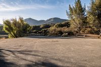 empty empty parking lot with mountains and trees in the background on a sunny day stock photo