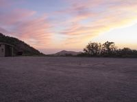 a desert area with rocks and bushes and sunset in background at a campground with two doors