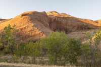 this is a view of the mountain from the road at sunset with light on the hills