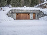there is a covered garage under the snow with an open door on it near many trees
