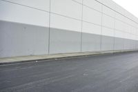 a white building on the street next to the road with a white line painted on the side