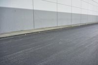 a white building on the street next to the road with a white line painted on the side