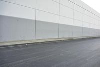 a white building on the street next to the road with a white line painted on the side