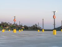 the parking lot has multiple signs on it's posts and poles, as well as street lights