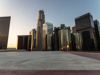 a wide city street at sunset with several tall buildings, buildings and traffic lights in the background