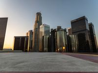 a wide city street at sunset with several tall buildings, buildings and traffic lights in the background