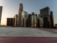 a wide city street at sunset with several tall buildings, buildings and traffic lights in the background