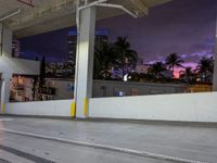 a skateboard parked under a high rise building next to a road with buildings and palm trees