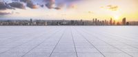 the sun shines down over a tiled floor in front of cityscape with clouds