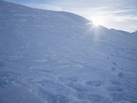 a person on skis standing on top of a snow covered hill by the mountains