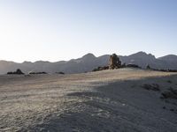 a view of a large rock formation with a person walking up the hill to it