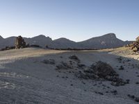 a view of a large rock formation with a person walking up the hill to it