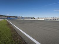 the green road and orange and white stripe line at an event near the racetrack and stadium