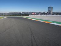 the green road and orange and white stripe line at an event near the racetrack and stadium