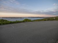 the parking lot by the water at dusk is empty and ready to be used for skateboard