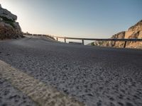 a highway on the side of a rocky hill in europe and on the far side there are bridges