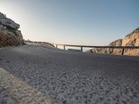 a highway on the side of a rocky hill in europe and on the far side there are bridges